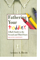 The cover of Fathering Your Toddler, a book featuring a men's button-down shirt with a few stray crayons in the front pocket.