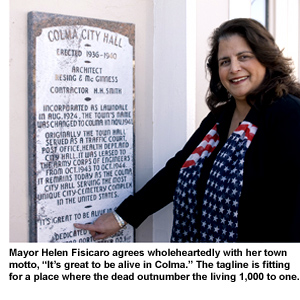 Helen Fisicaro, the mayor of Colma, pauses outside City Hall to point to a plaque bearing her town's motto.