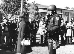 Photo of a female student and a policeman holding flowers she had just given him.