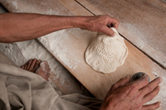 Steeped in flour, a skillful hand stamps patterns into bread bound for Afghan Border Police in Goshta distric