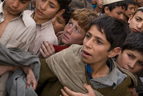Boys crowd together while waiting for the distribution of humanitarian goods distributed by the Afghan National Army