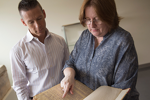 Picture of Meredith Eliassen and Luca Facchin examining treatise by Vincenzo Galilei from 1581. Photo by Paul Asper