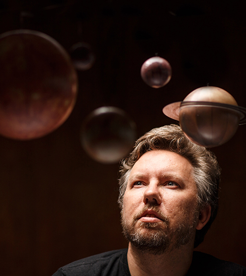 Stephen Kane looks up at hanging models of planets. Photo by Steve Babuljak
