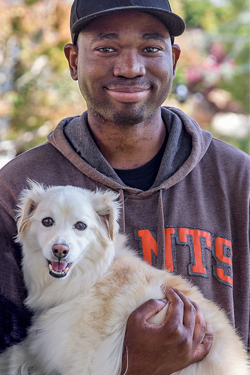 Gesean Lewis Woods holding a white dog