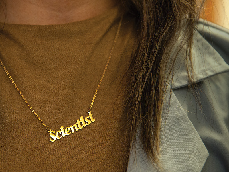 Close up of a necklace worn by person with long hair