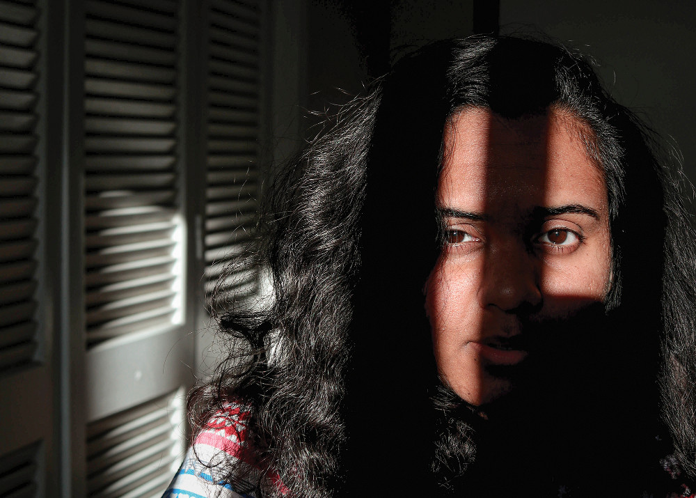 Close-up of a person's face, partially lit by sunlight through a window