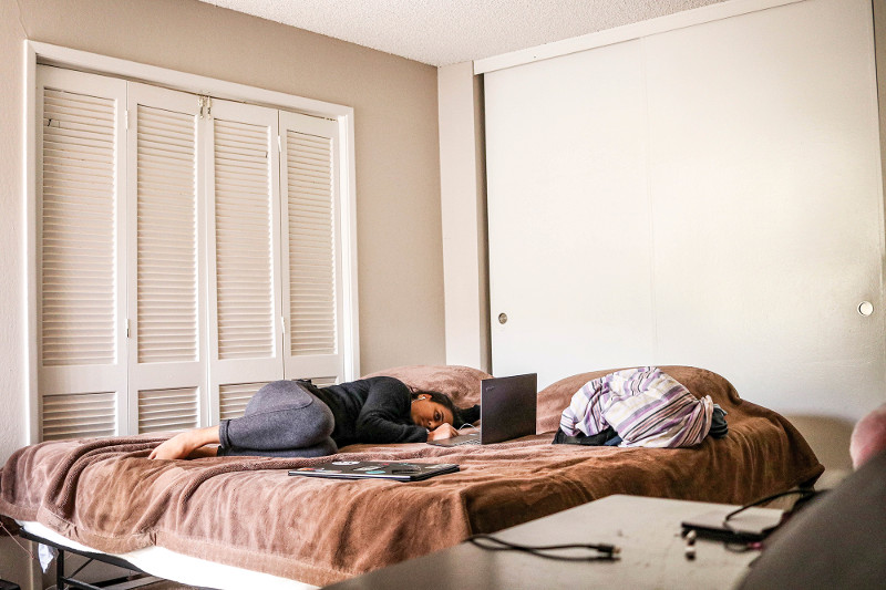 Person using laptop on a bed