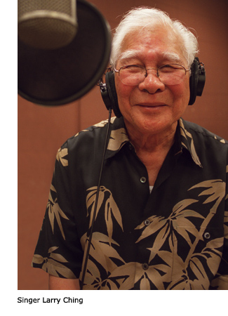 Singer Larry Ching smiling with headphones clad in a Hawaiian shirt.