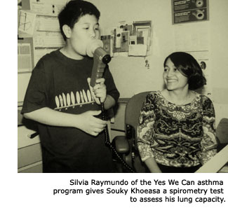 A young man named Souky Khoeasa blows into a hand-held device to test his lung capacity under the careful watch of Silvia Raymundo, a Yes We Can staff member.