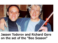 Music Professor Jassen Todorov smiles next to actor Richard Gere who has one arm around Todorov and a violin in the other.