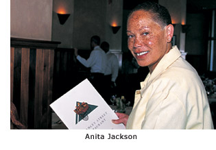 New graduate Anita Jackson smiles as she delivers a menu to a customer at the Delancey Street restaurant.