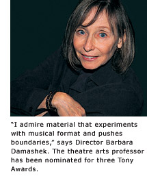 Theatre Arts Professor Barbara Damashek smiles from a seat in a darkened theater.