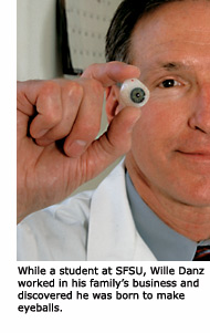 Alumnus Willie Danz holds up an eye he has crafted for a patient.