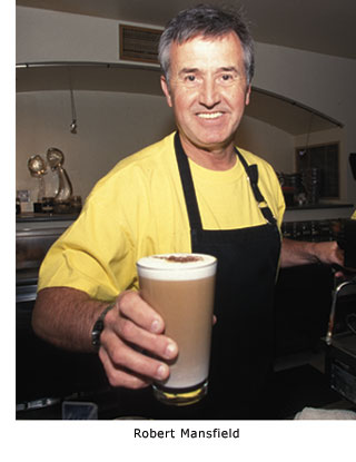 New graduate Robert Mansfield smiles as he delivers a tall, foamy latte to a customer at the Delancey Street Cafe.