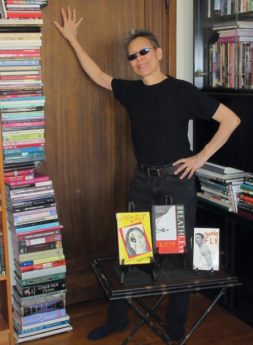 Kitty Tsui alongside stack of books