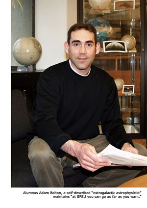 Adam Bolton pauses in his research at his Harvard office. Several globes can be seen in the background.