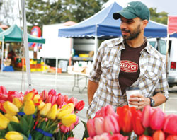 Photo of restauranteur and "Iron Chef" winner Mourad Lahlou perusing flowers at a farmers market