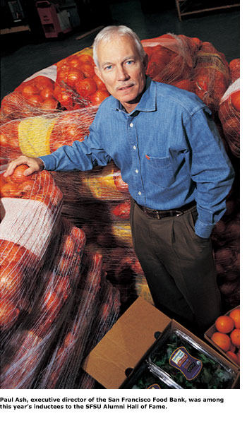 Alumnus Paul Ash stands among several bushels of tomatoes at the San Francisco Food Bank