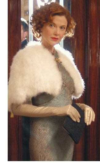 Annette Bening as Julia Lambert stands in a fur stole and sparkly gown