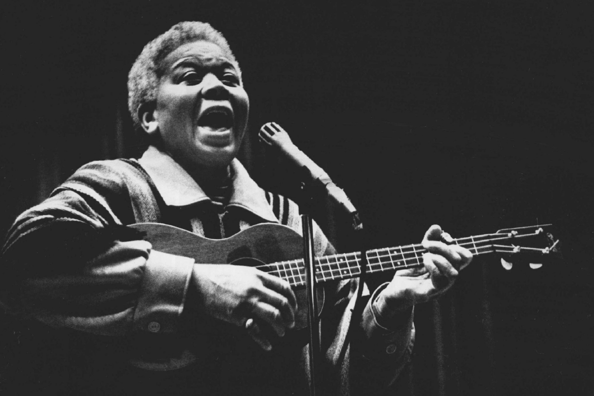 Ella Jenkins singing and strumming guitar for performance