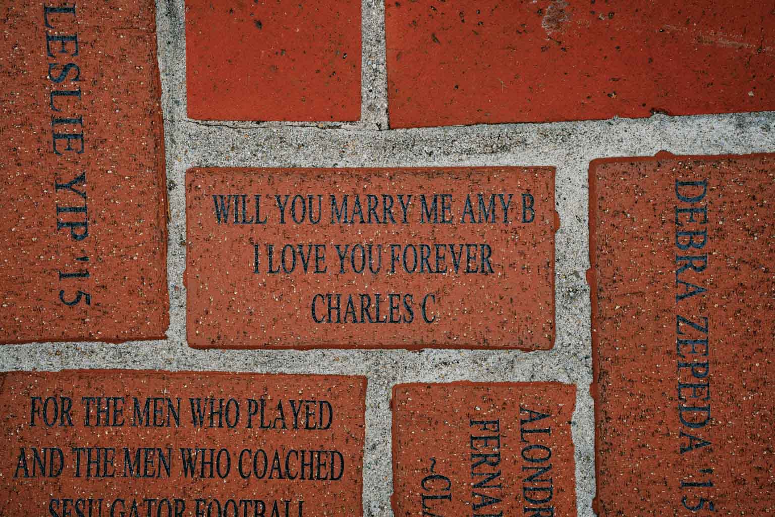A wedding proposal engraved on a brick