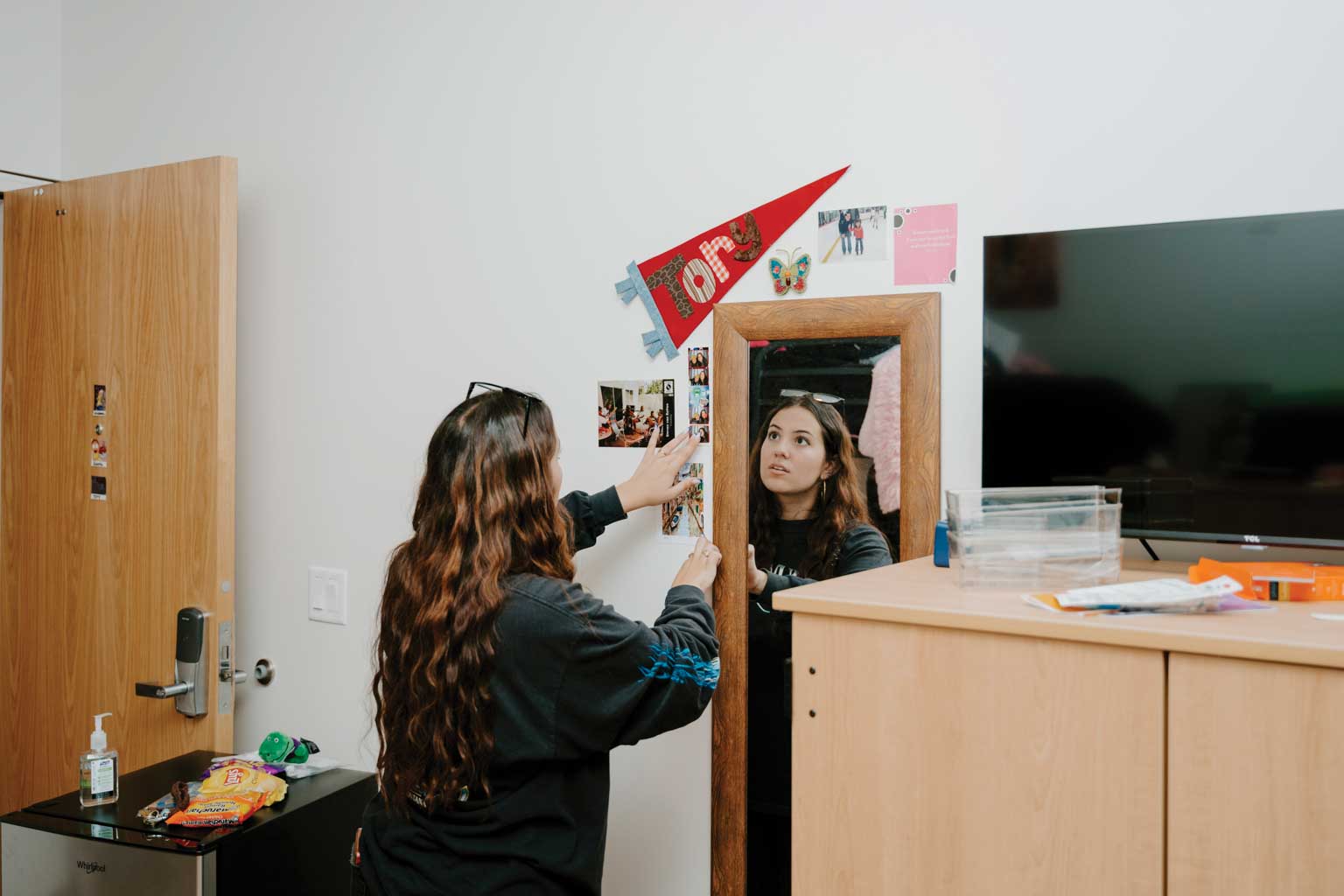 SFSU student decorating her dorm room wall