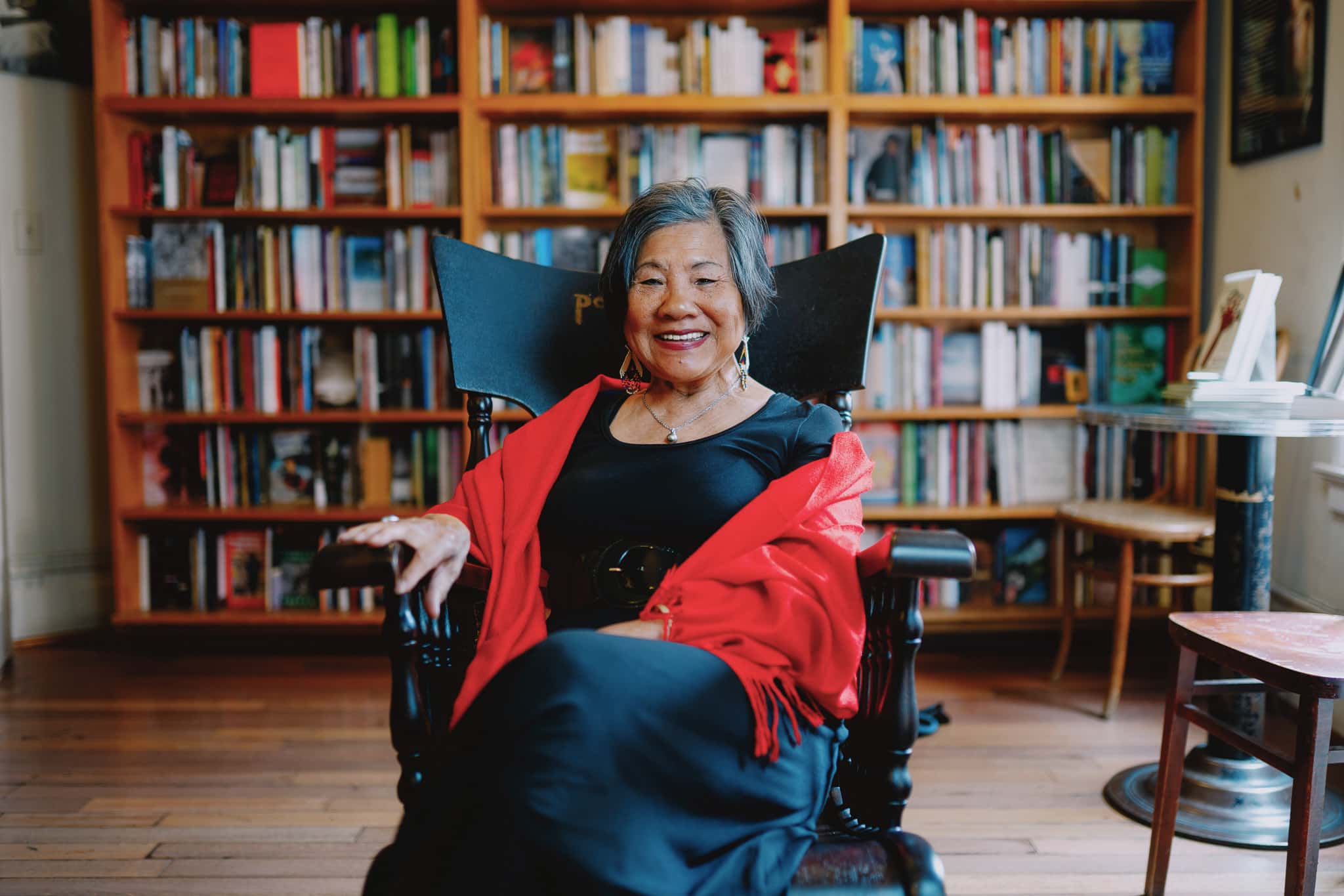 Genny Lim sits on a rocking chair in the poetry room