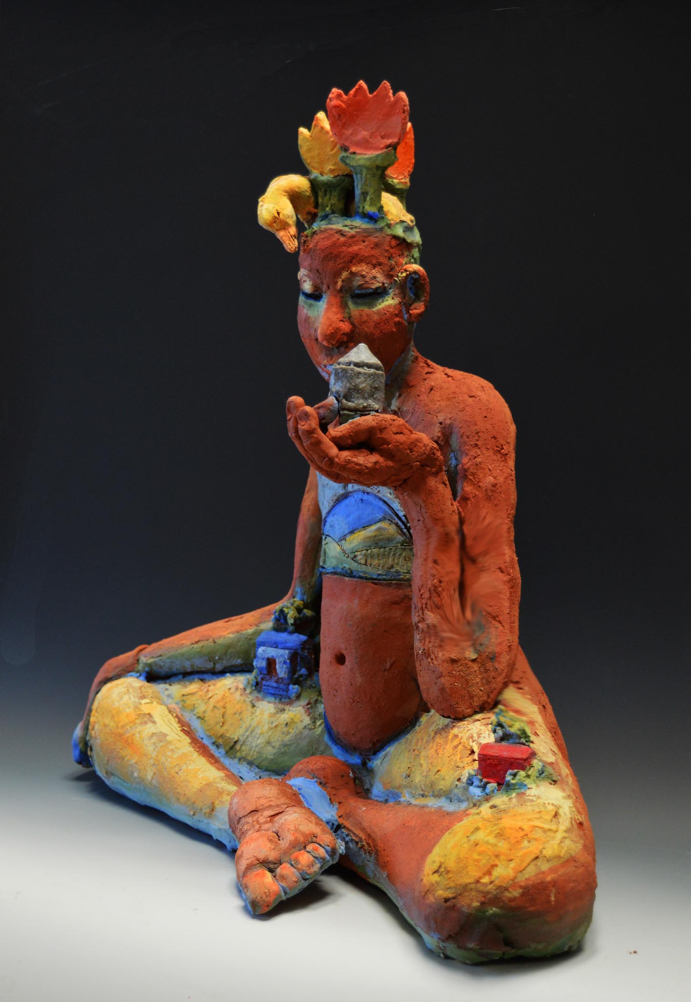 Sculpture earthlike human figure sitting and holding up a building featured in "Connection:Artaxis"
