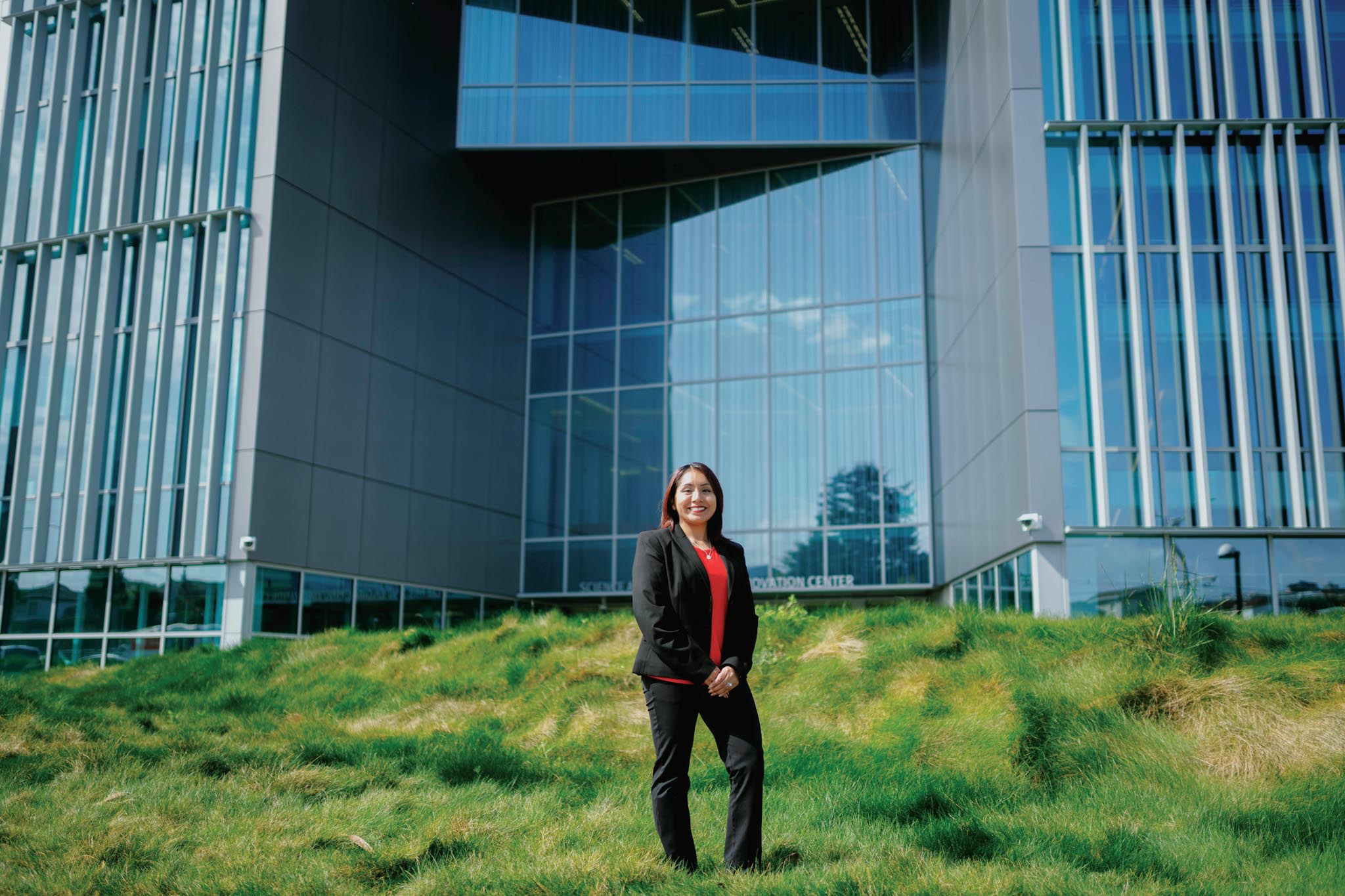 Alumna Leslie Valencia standing in front of the newly built Science & Engineering Innovation Center