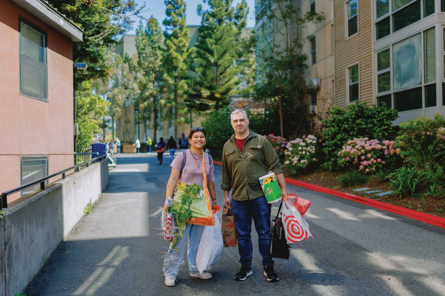 Student and their parent carrying groceries towards dorm room