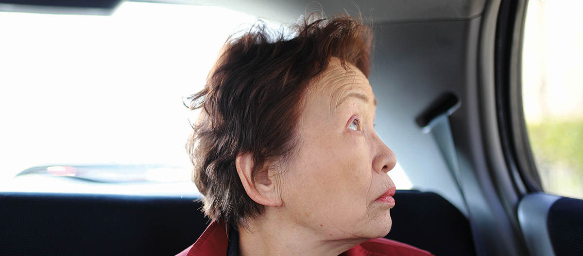 Asian woman looking out car window 