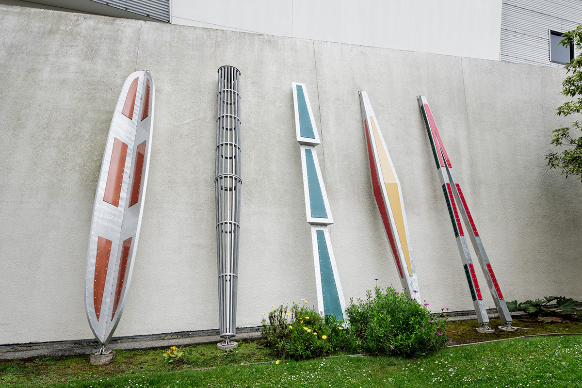 Aluminum totems propped up on the side of a wall