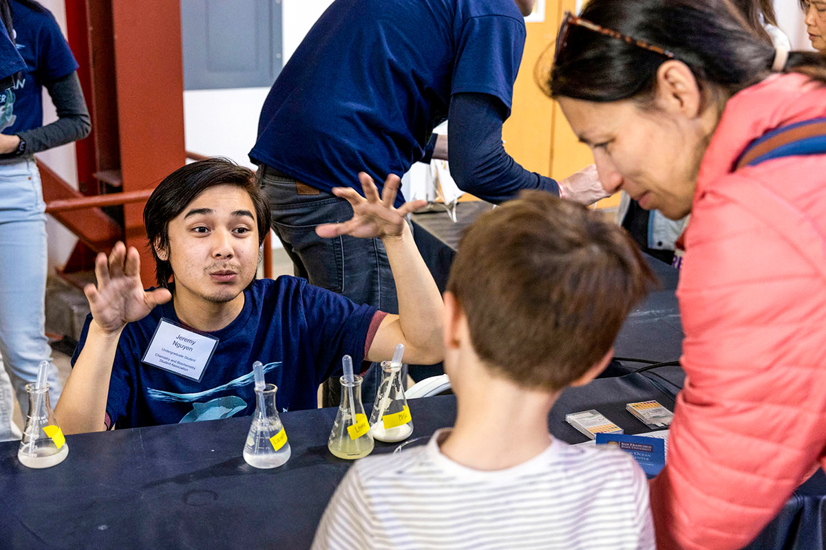 A student teaching a child about chemistry