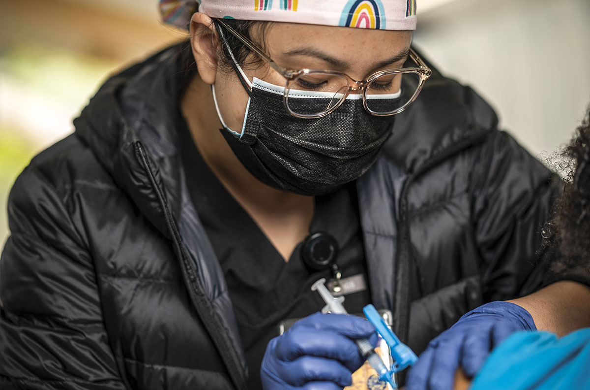 nursing student giving a COVID-19 vaccine 