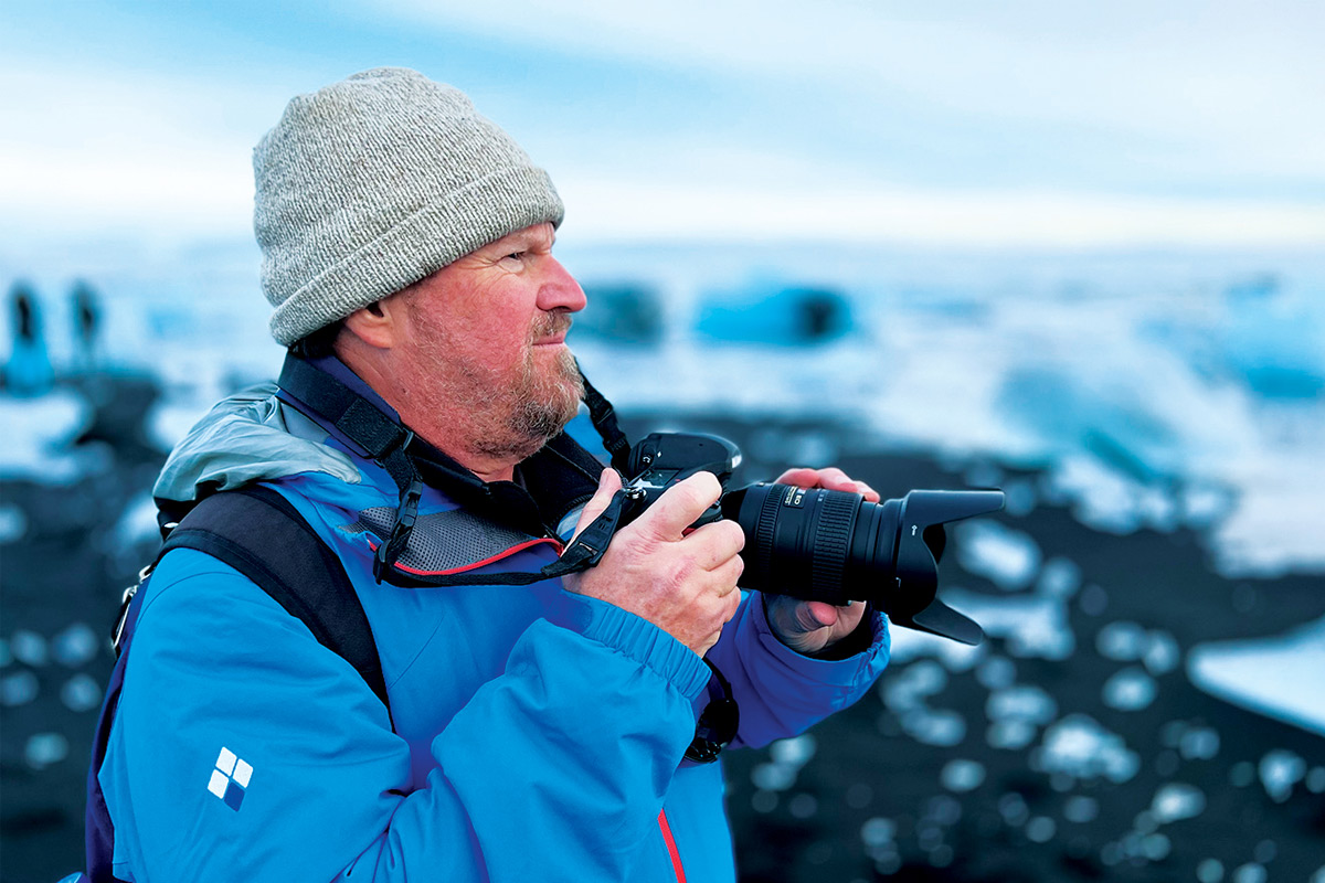 Bruce Borowsky holding a dslr camera and dressed in winter clothes