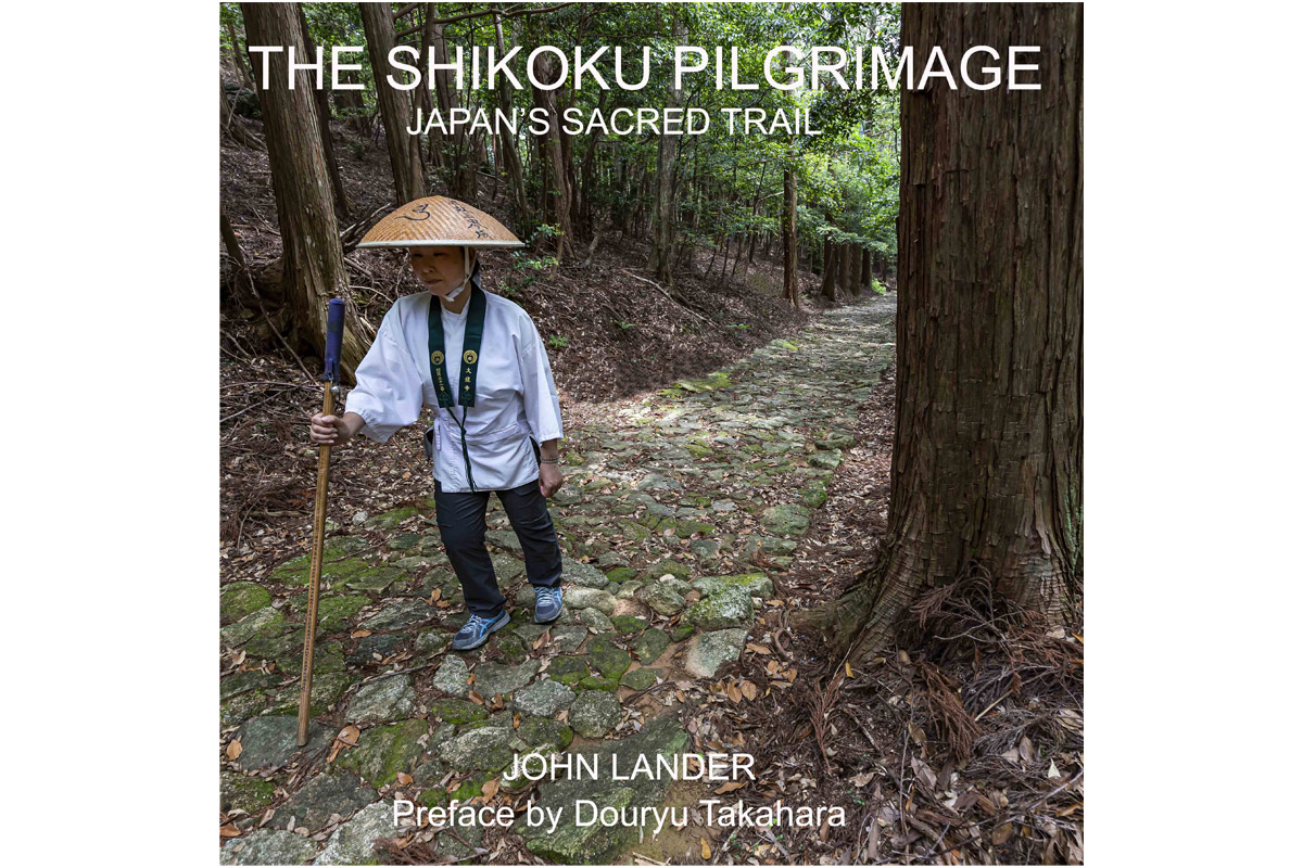 cover art of The Shikoku Pilgrimage showing a hiker wearing a stray hat holding a walking stick walking through a path