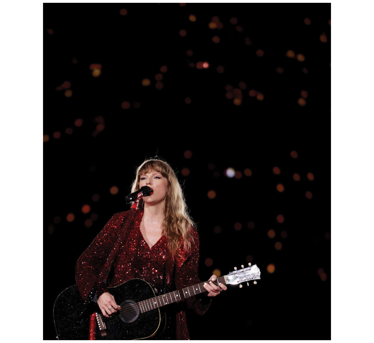 Taylor Swift holding a guitar and singing