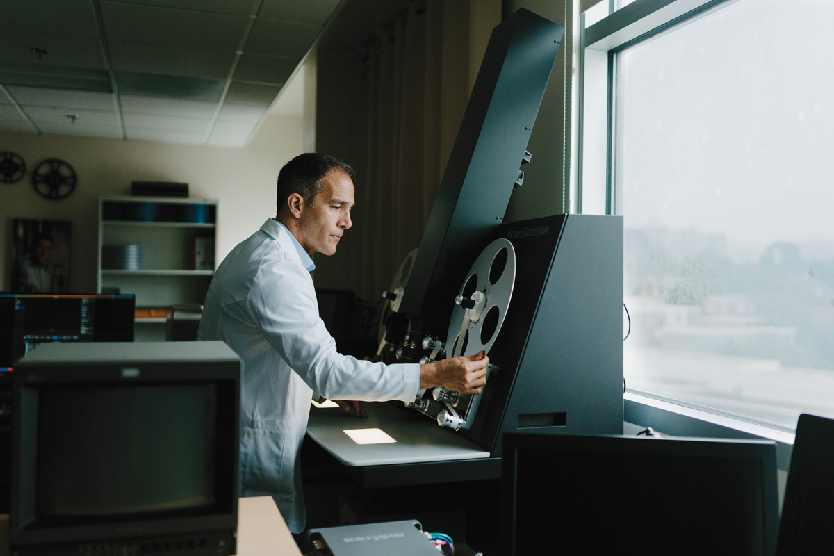 an archivist rolling a film reel