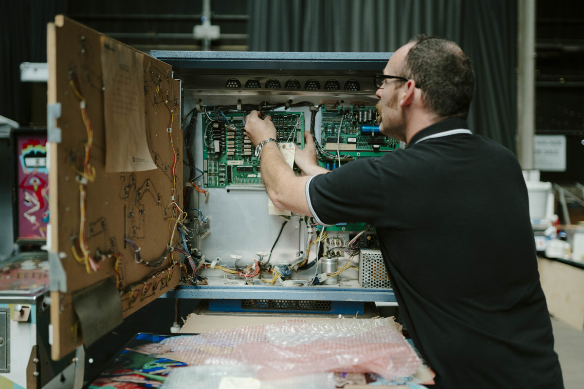 Evan Phillippe connecting electrical wires for a pinball machine