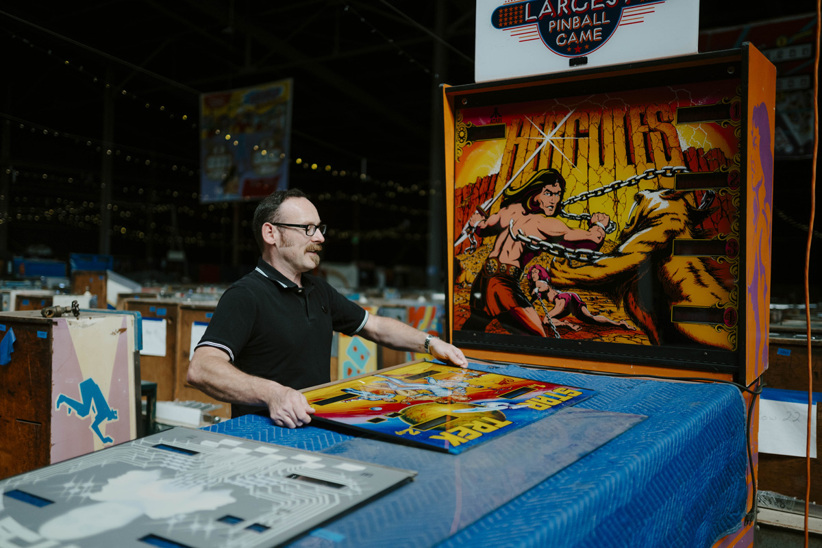 Evan Phillippe (B.A., ’04) setting up a pinball machine