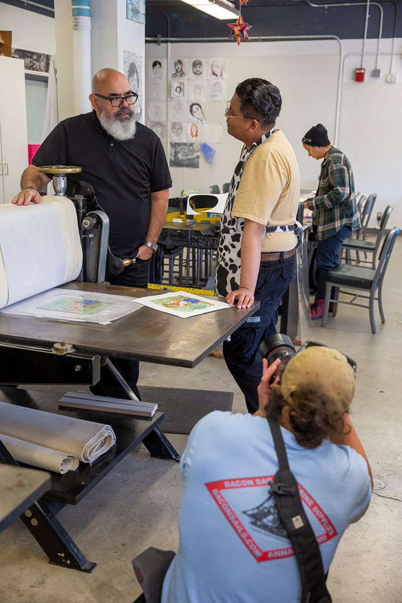 Benjamin Fanjoy photographing VictorDe La Rosa working with students