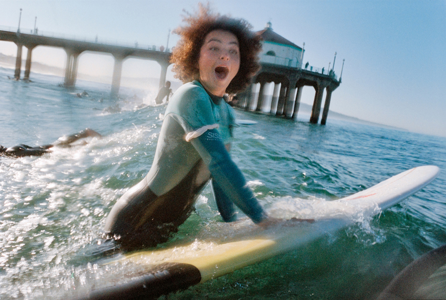 a female surfer excitedly surfing