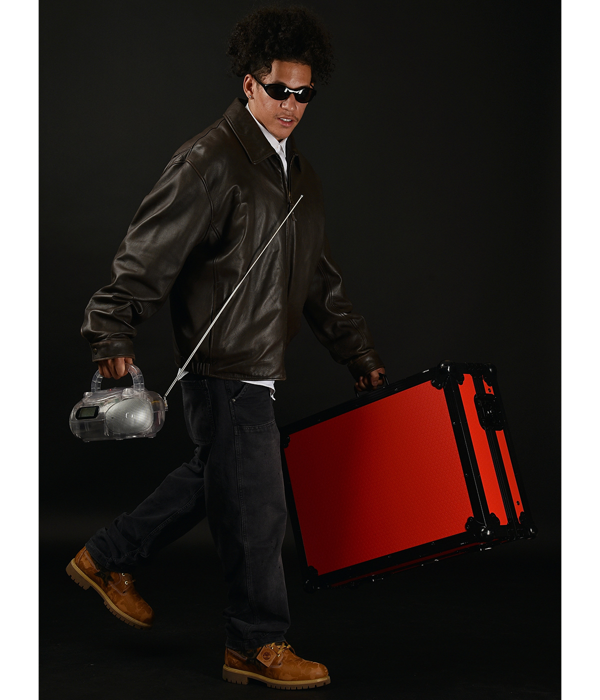 Solomon “DJ Solo” Orr holding a radio and a red briefcase